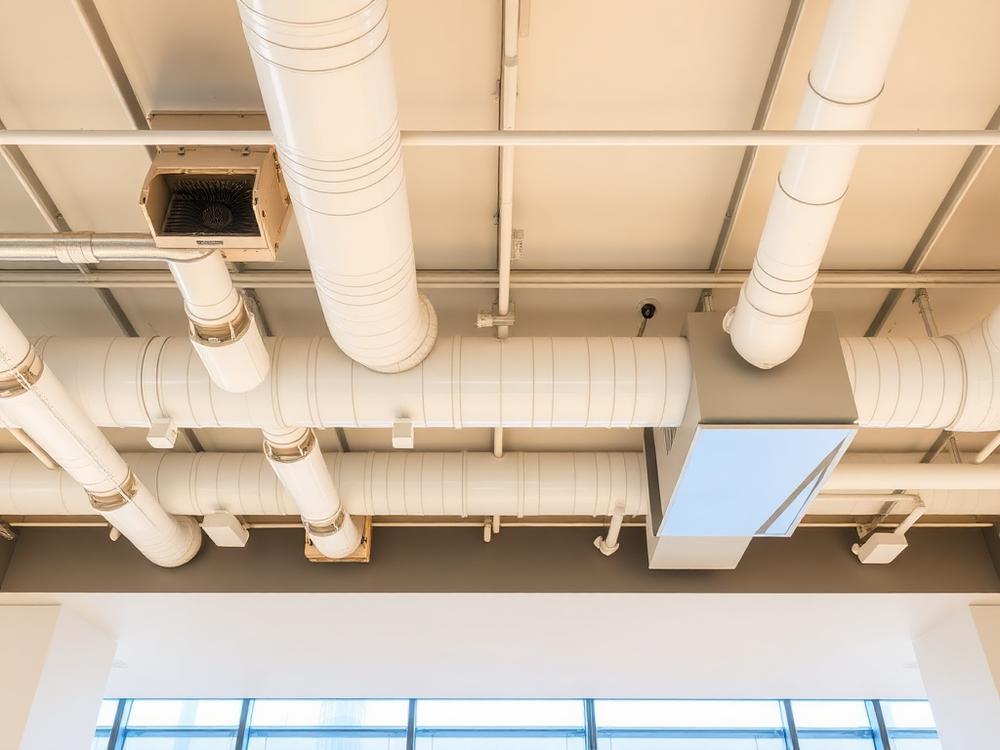 Réseau de gaines de ventilation installé au plafond d'un bâtiment